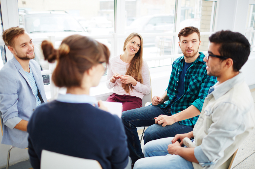 Group of young people communicating at psychological course