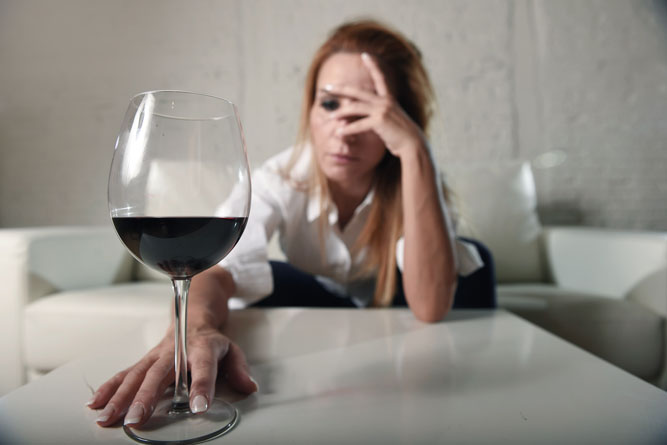 woman staring at glass of wine