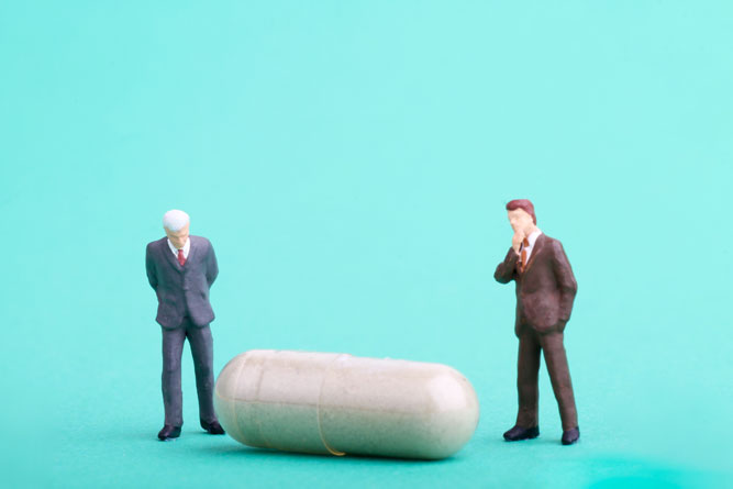 two pharmaceutical men with pill