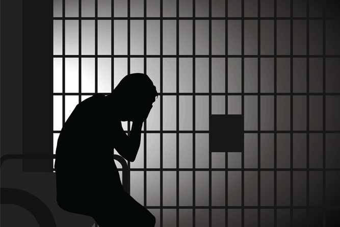 man sitting in jail cell