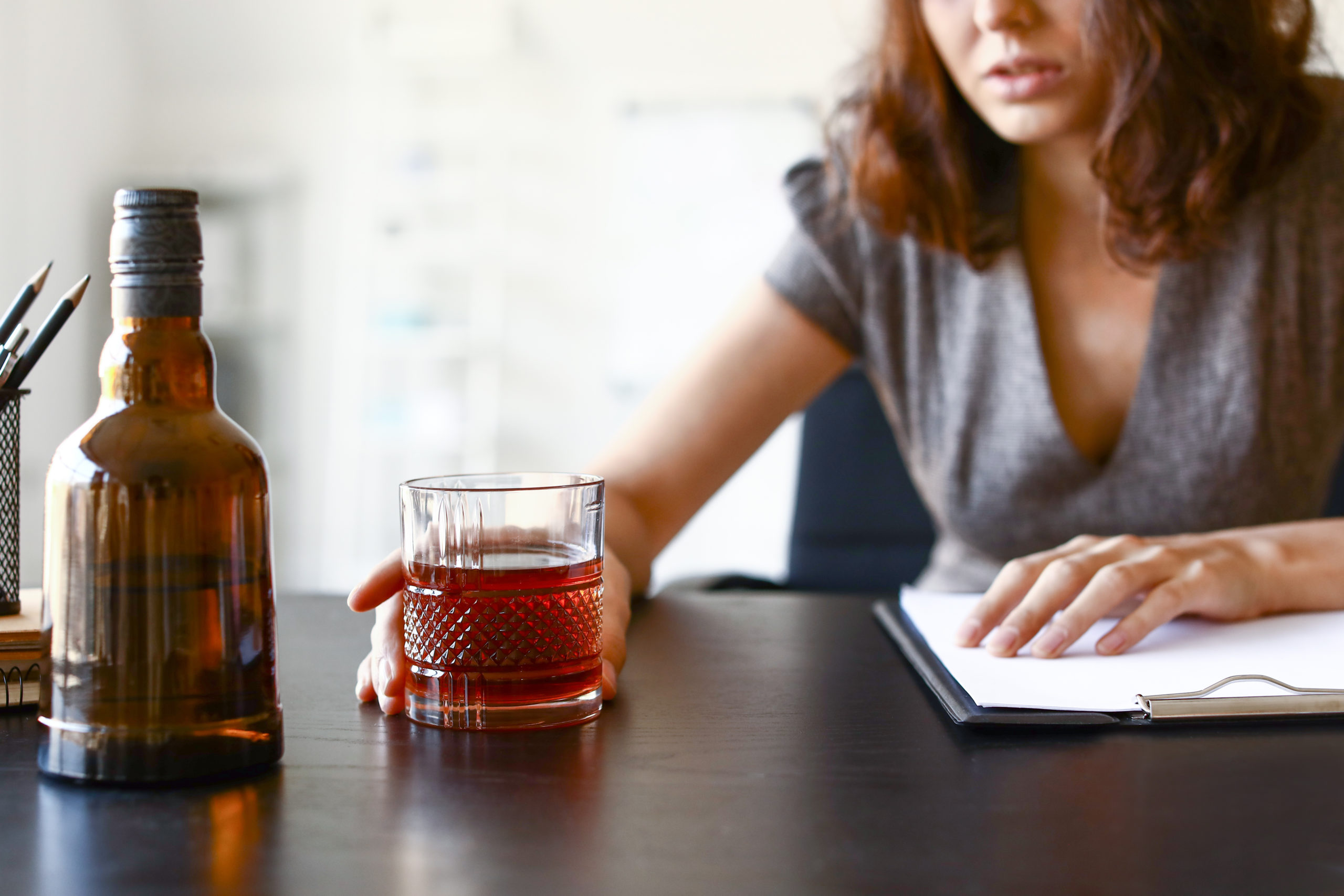 woman who has become an alcoholic reaching for a drink