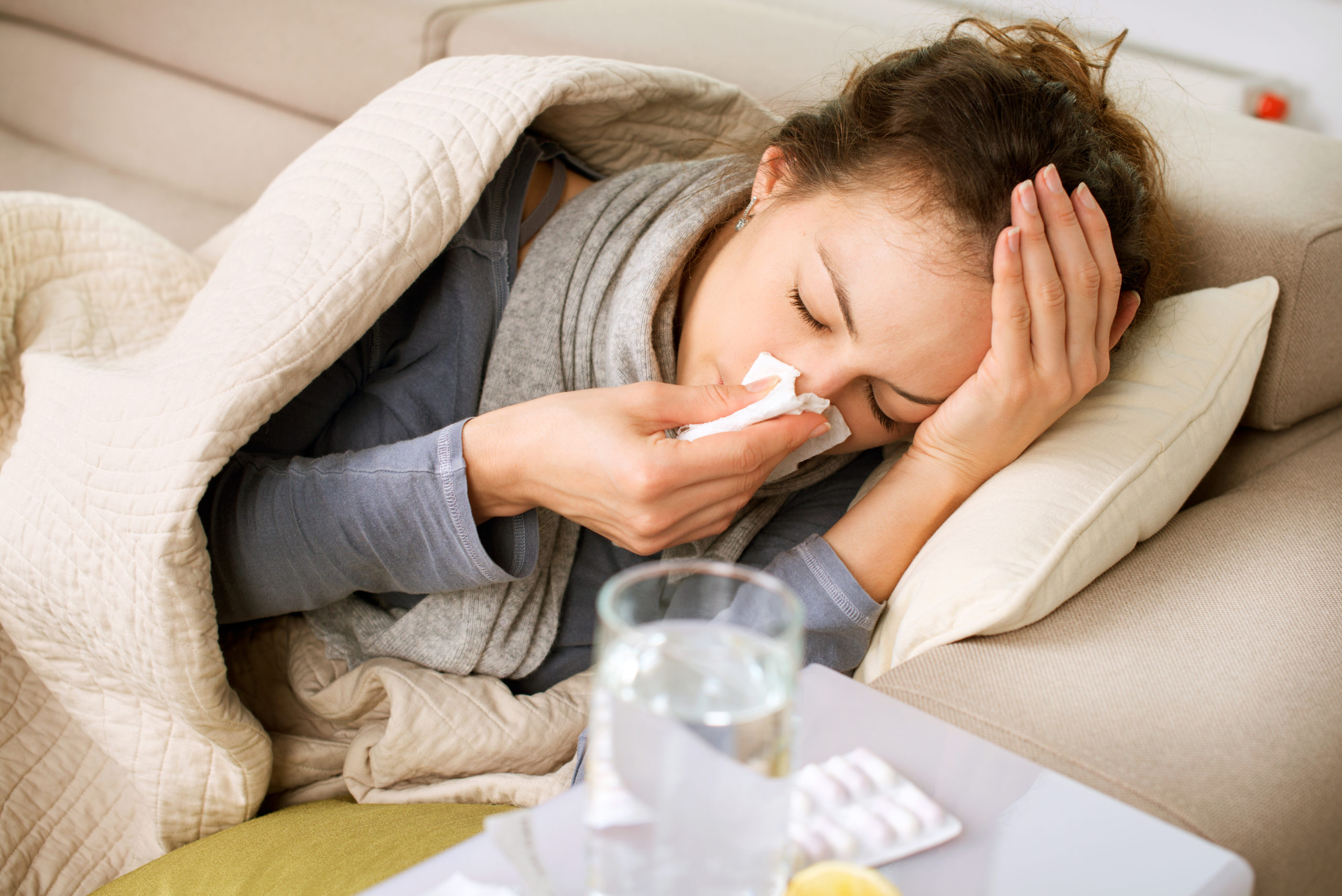 sick woman on couch feeling like she will die from heroin withdrawal