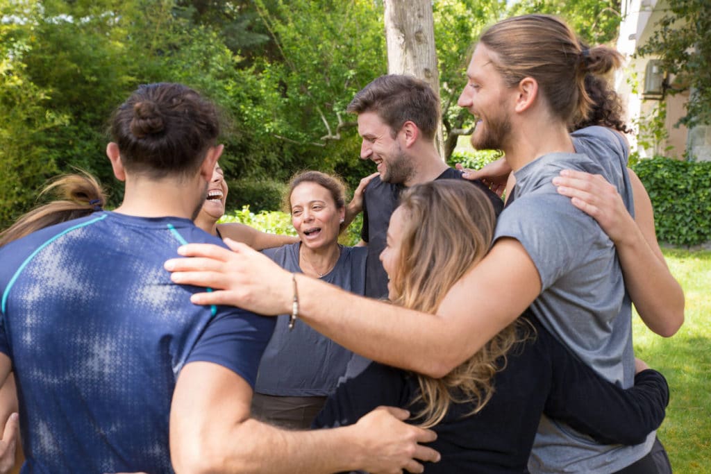 Group of happy people embracing each other
