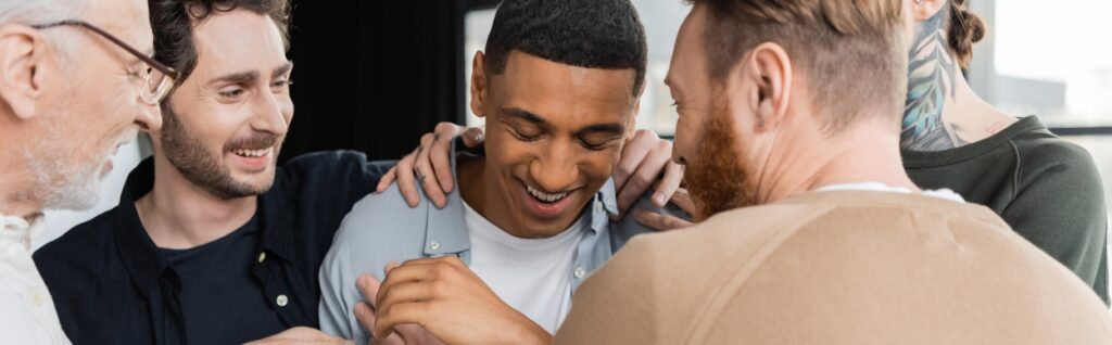 A man is comforted after sharing his experience during recovery treatment.